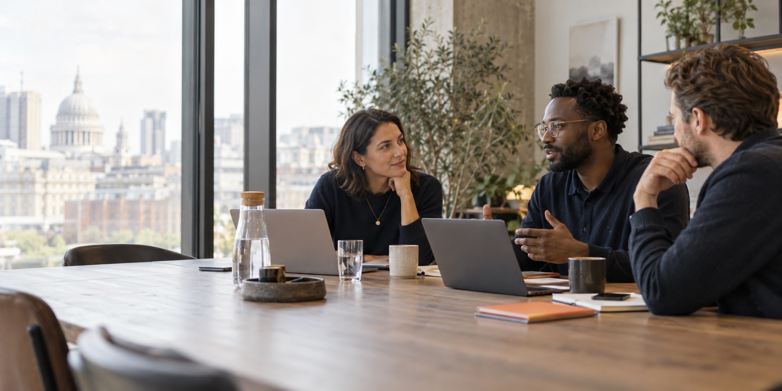 Three technology professionals discussing a hiring brief in a London office